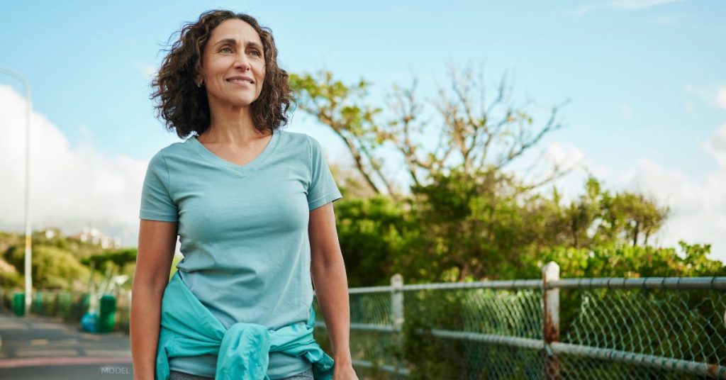 middle aged woman (model) walks to get exercise.